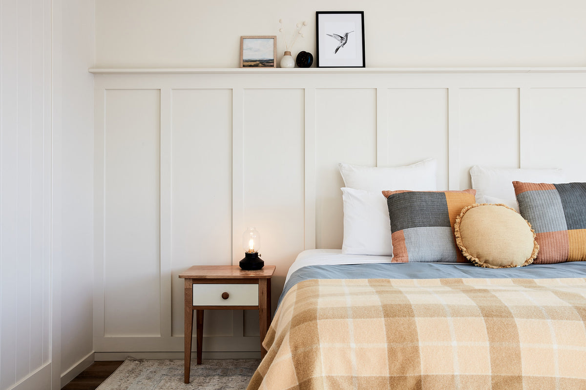A bedroom at Lakeside Villas with a checked blanket and soft light