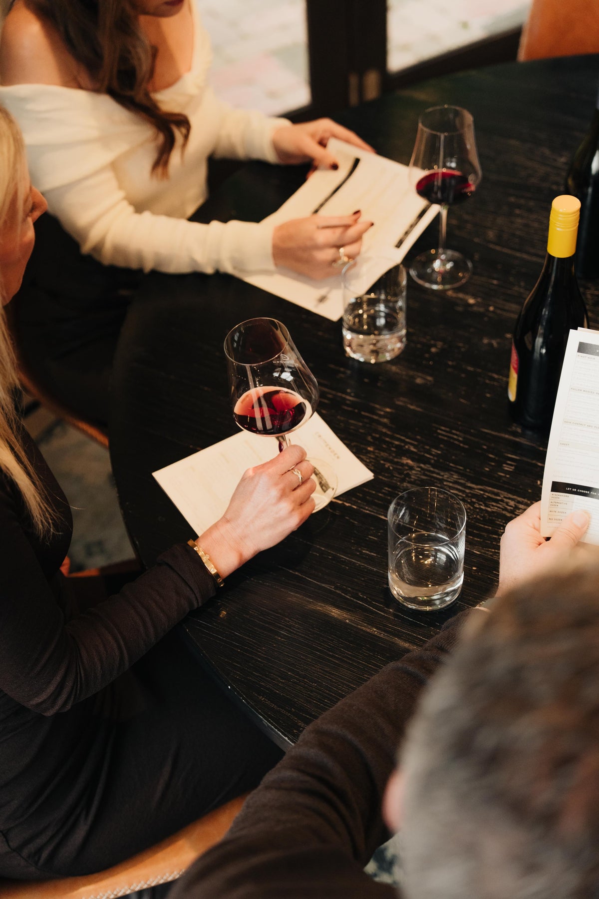 Guests making tasting notes over glasses of red wine