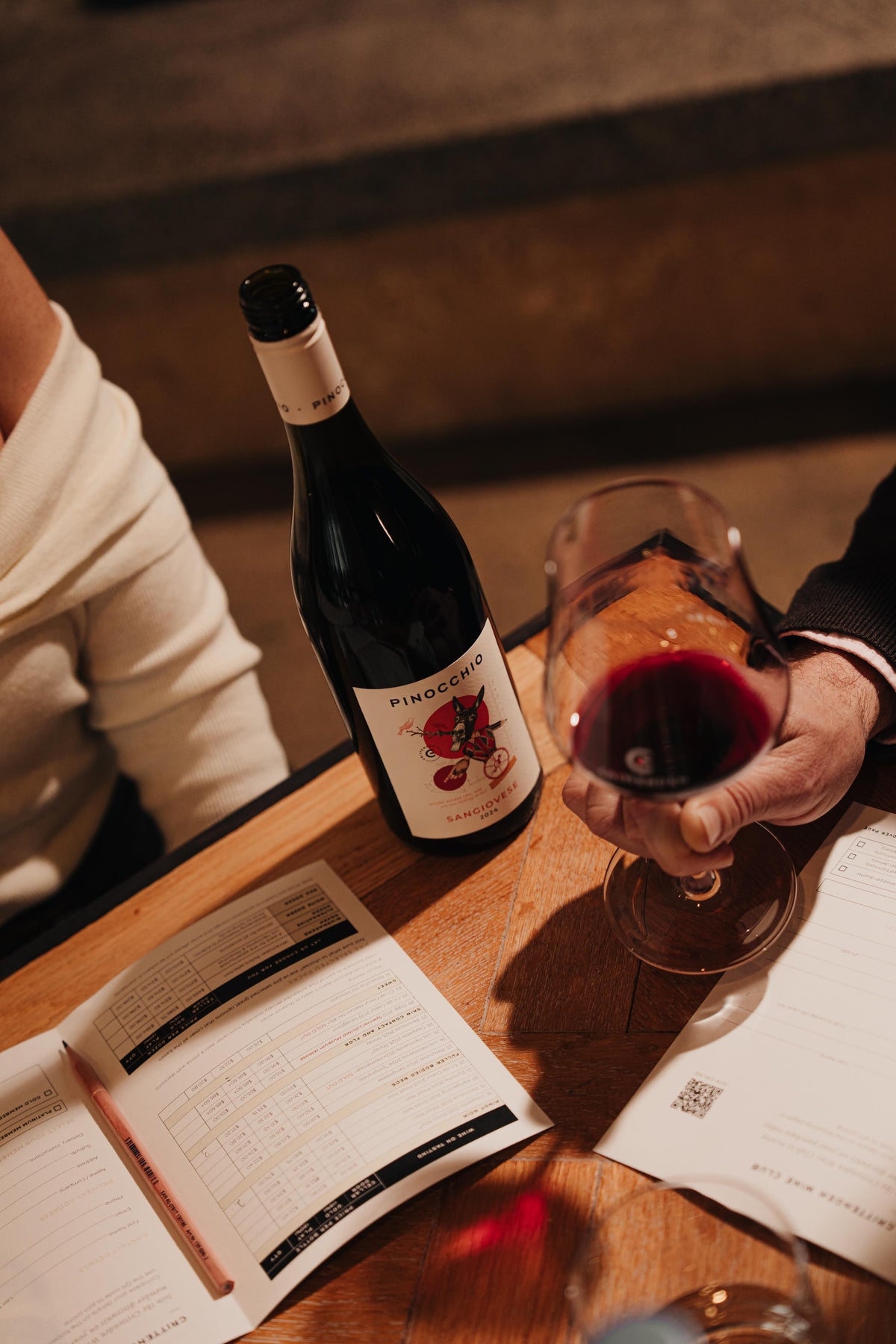 A glass of red and a bottle of Crittenden red on a tasting table