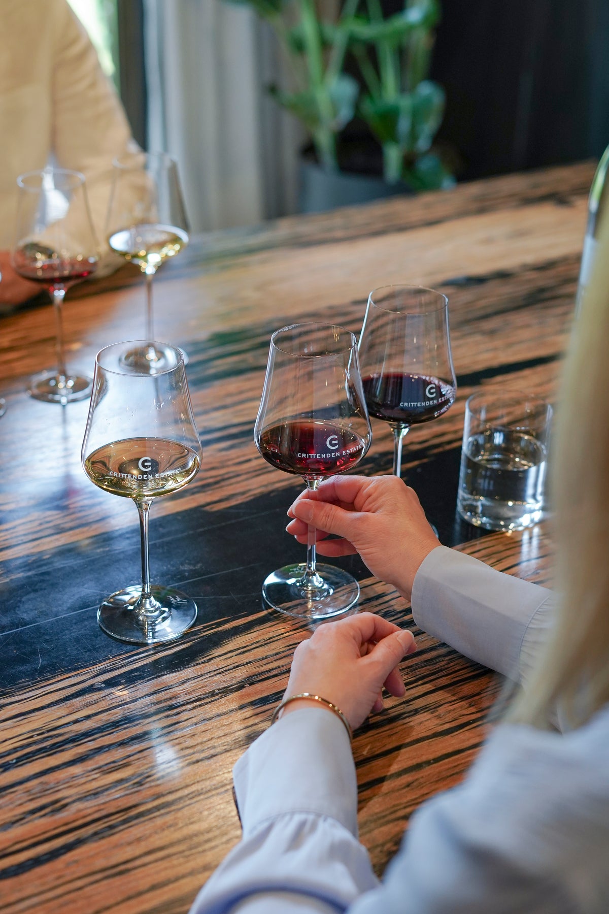 A guest holding a glass of red with white wines poured alongside