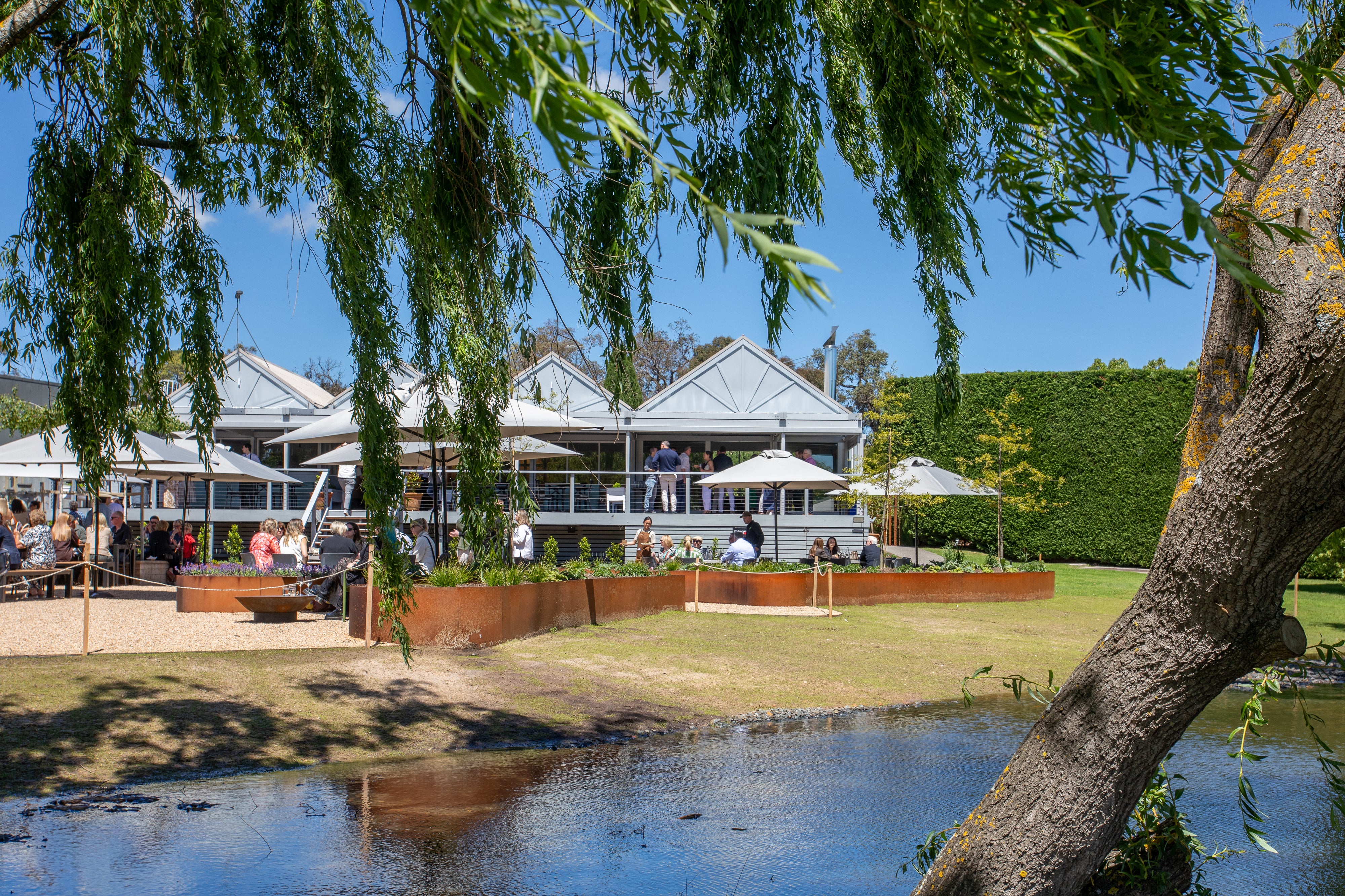 The restaurant and Terrace seen across the lake under willow branches