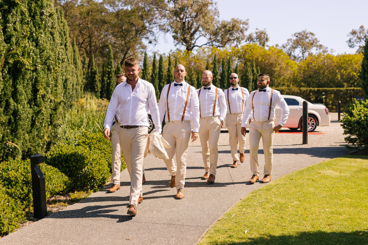 A groom and groomsmen walking up the garden path