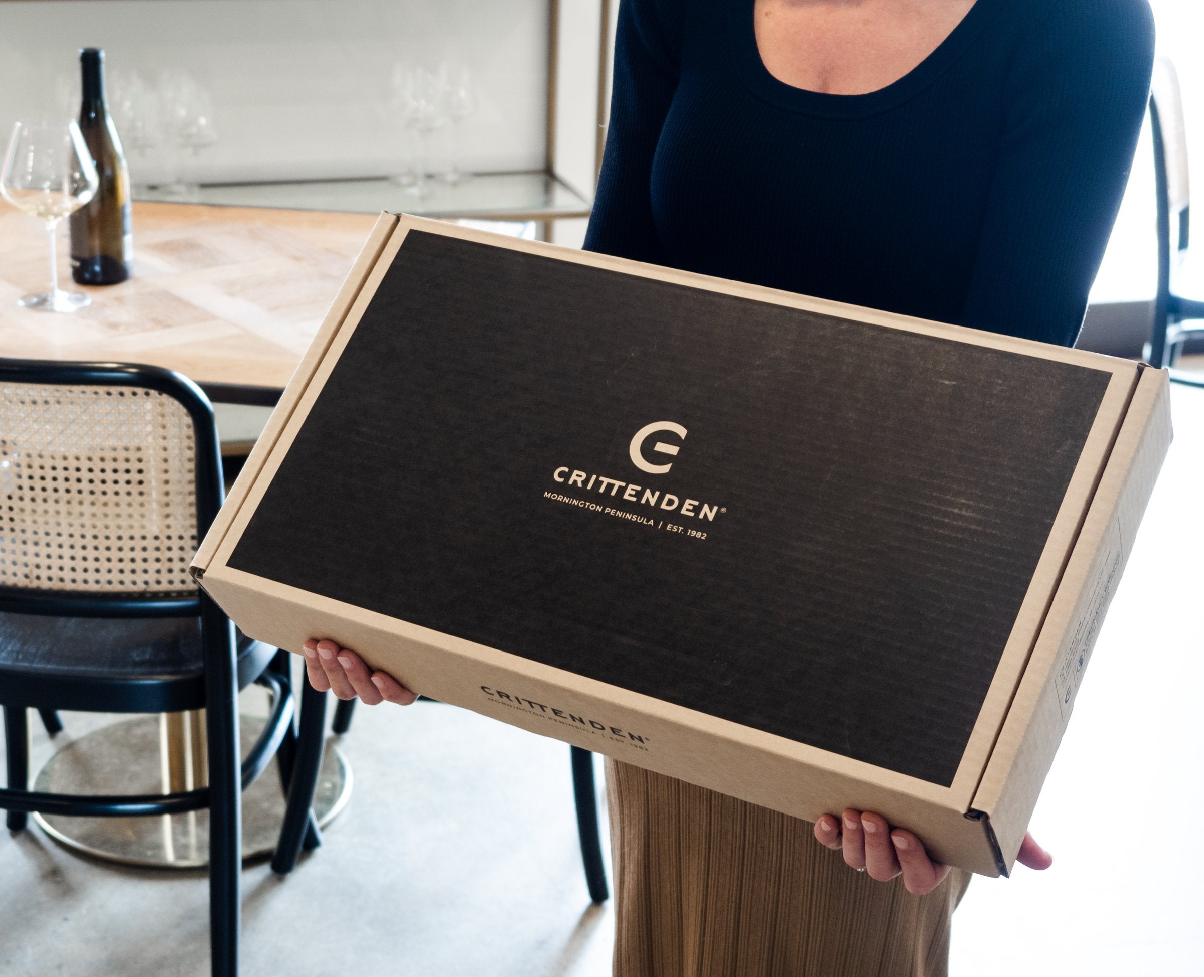 A Crittenden wine club box held in two hands